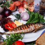 Delicious grilled fish served with fresh Mediterranean vegetables and bread.